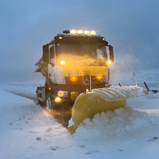 Snow plough clearing road in Cheshire East